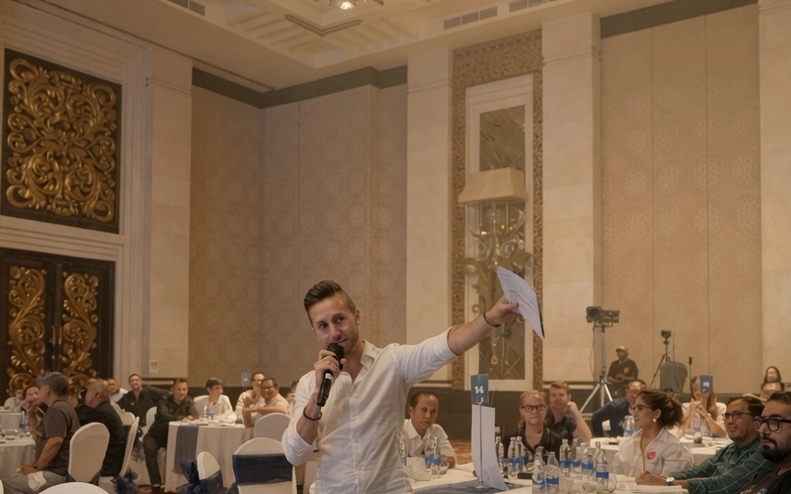 Cal Amir leading a corporate session in a hotel ballroom